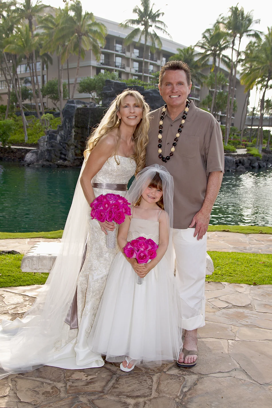 Tom and His Wife at their wedding with a flower girl posing with them