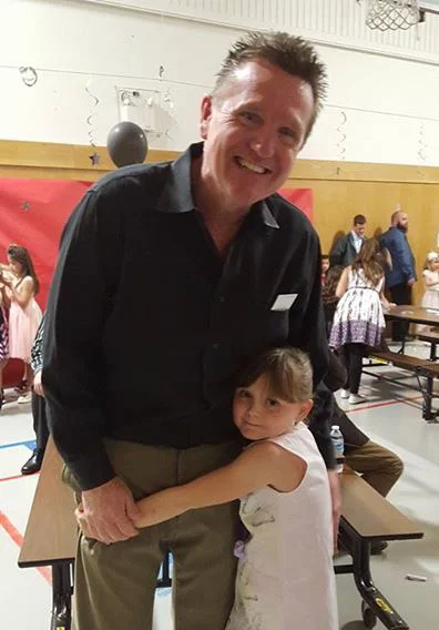 Tom and a young boy hugging